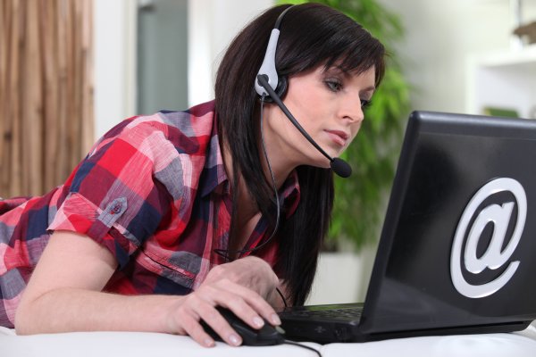 woman with headset on laptop voip dark hair
